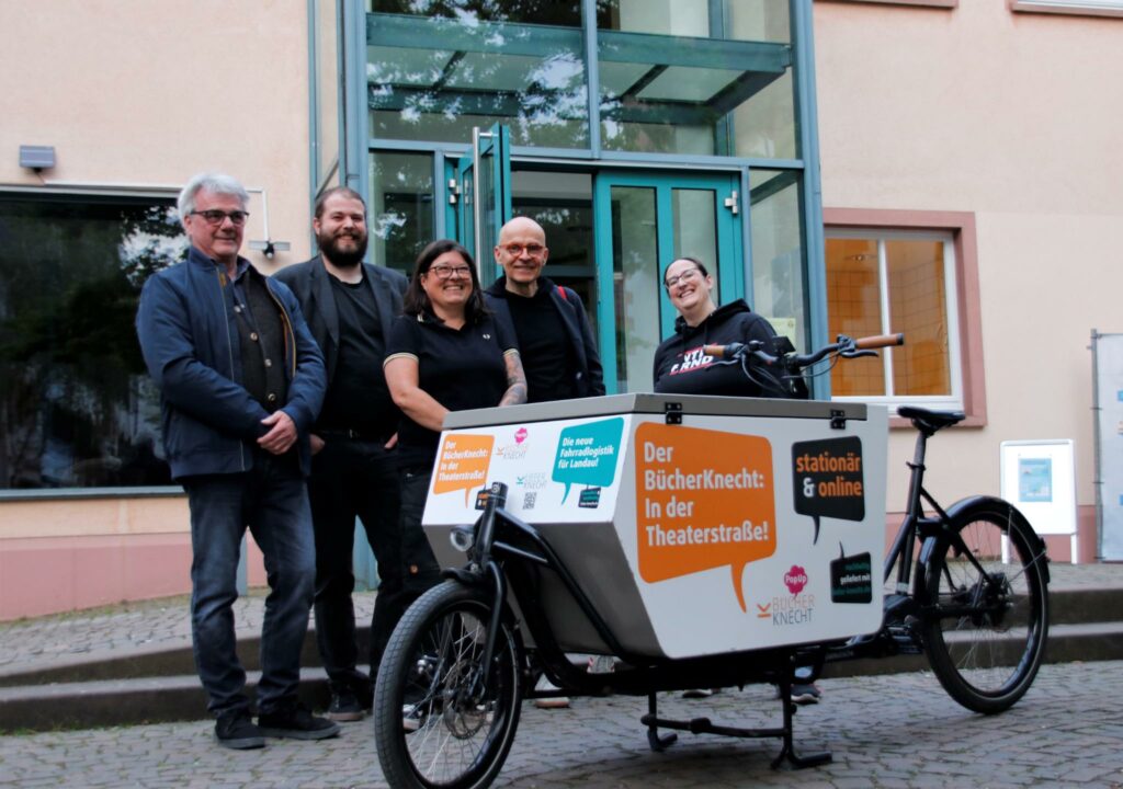 Die Veranstaltenden mit dem Vortragsrefernten vor dem Gemeindehaus mit Lastenrad von Bücherknecht.
von links nach rechts: Markus Knecht (Bücherknecht), Jan Wiese (Gedenkstätte NW), Tanja Sattler ( ToM Südpfalz e.V., Markus Rieger-Ladch, Uni Tübingen und Alice Fuß (Naturfreundejugend RLP)